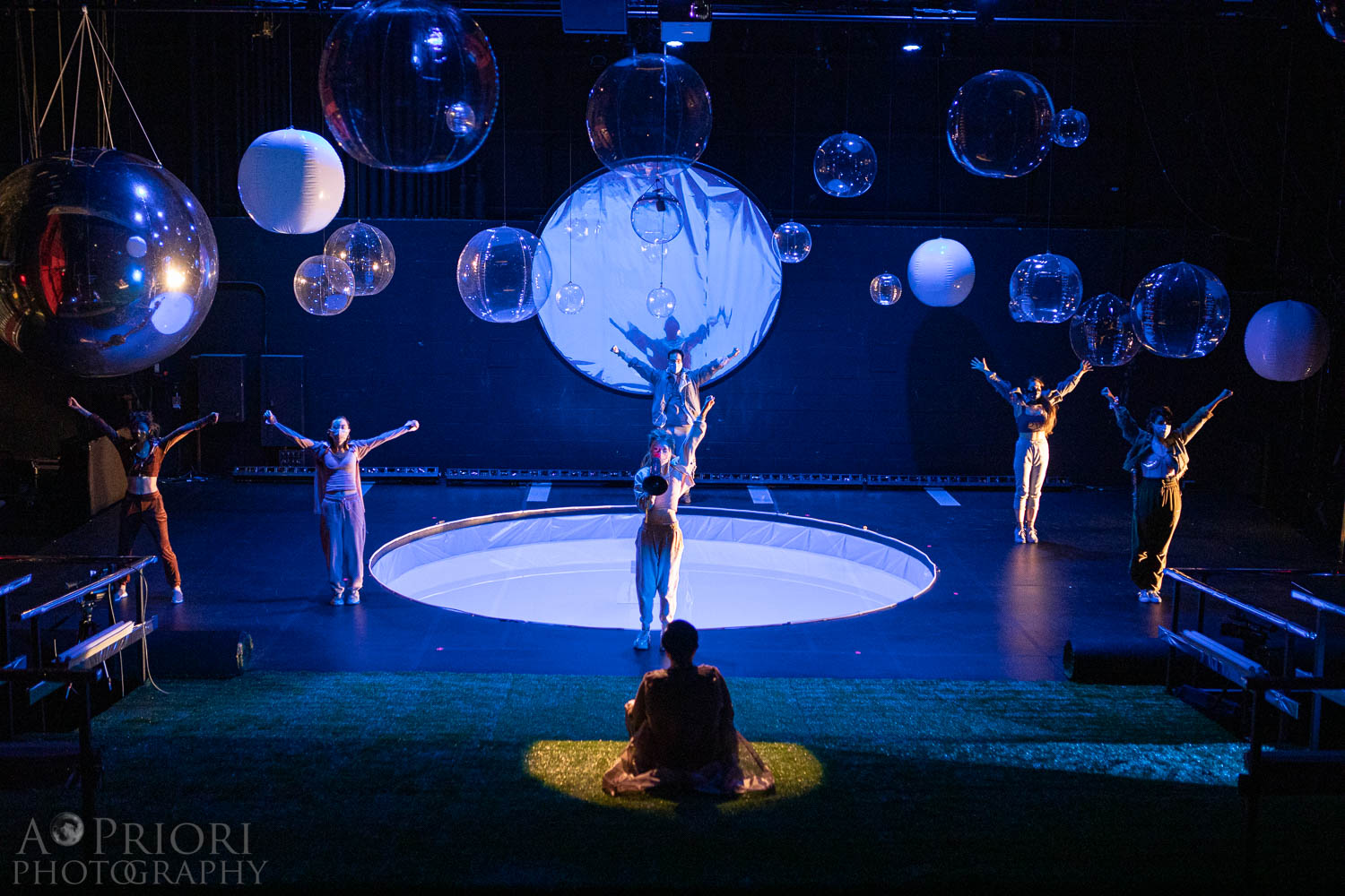 The cast of the TDM production of "and the grass grows" stands with their hands in the air