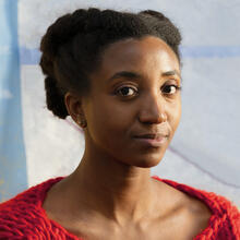 A Black woman wearing a red sweater