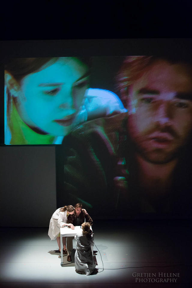 Two actors onstage with video projections of their face behind them