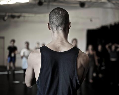 Shamel Pitts facing away from the camera at a room of dancers